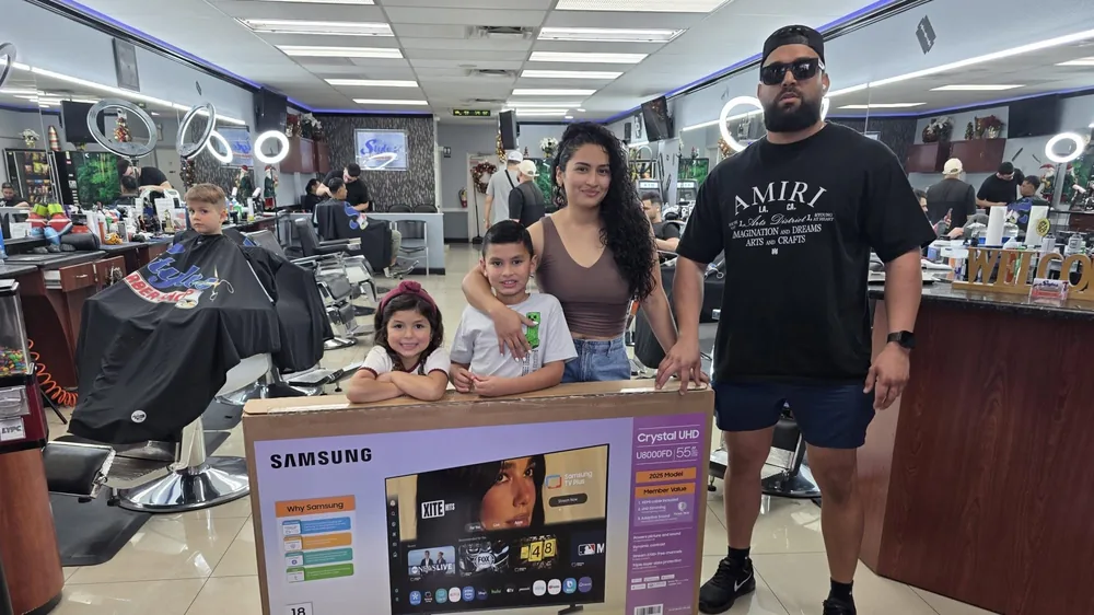 Christmas raffle winners with their Samsung TV at Styles Barber Shop